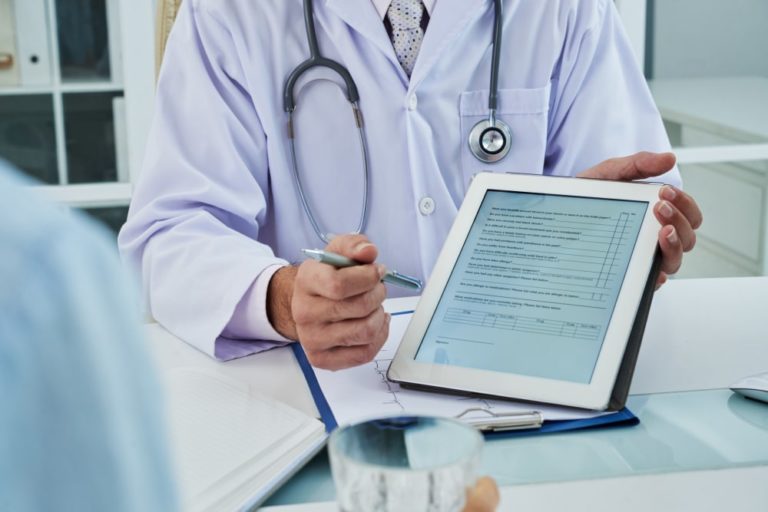 unrecognizable doctor extending digital tab anonymous patient fill questionnaire min